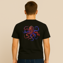 Charger l&#39;image dans la galerie, Person wearing a black t-shirt with a colorful octopus design on the back against a beige background