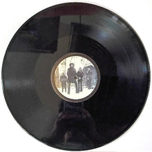 Load image into Gallery viewer, Black vinyl record with a circular label featuring a group of people in a snowy landscape.