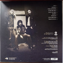 Charger l'image dans la galerie, Album cover with three people in a room, featuring text on a dark background
