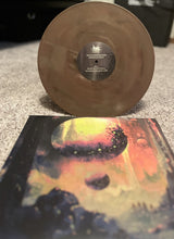 Load image into Gallery viewer, Brown vinyl record with a colorful cover on a textured surface