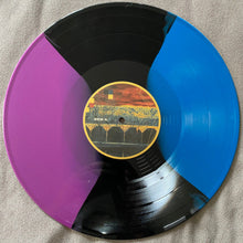 Charger l'image dans la galerie, Vinyl record with a colorful cover on a beige surface