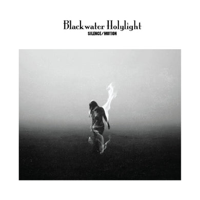Blackwater Holylight album cover for 'Silence/Motion' featuring a black and white photograph of a person with arms raised, standing on a misty landscape.