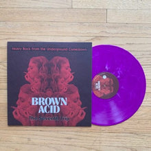 Cargar imagen en el visor de la galería, Vinyl record with purple disc and black cover featuring 'Brown Acid' on a wooden surface
