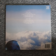 Cargar imagen en el visor de la galería, Vinyl record cover with cloud and planet design on a textured surface