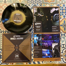 Cargar imagen en el visor de la galería, Vinyl record with its cover displaying text and images on a patterned surface