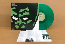 Charger l'image dans la galerie, Green vinyl record with black and green camouflage cover on a wooden surface