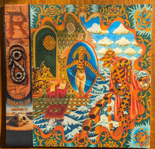Charger l'image dans la galerie, Colorful book cover with a tiger, desert scene, and decorative elements on a wooden surface.