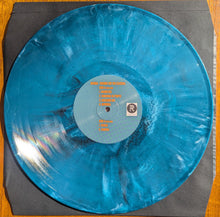 Charger l'image dans la galerie, Blue vinyl record with a label on a gray background