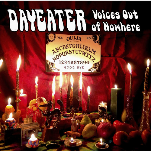 CD cover featuring a Ouija board with candles and various decorative items around it.