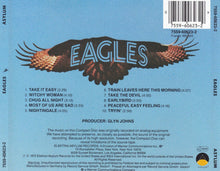 Cargar imagen en el visor de la galería, Back cover of an Eagles album with an eagle illustration and tracklist on a blue background