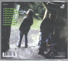 Cargar imagen en el visor de la galería, CD cover with a person smoking a cigarette on a stone path, surrounded by nature.