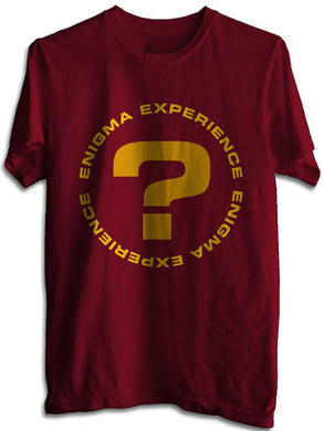 A maroon colored t-shirt with a circular text design that reads 'ENIGMA EXPERIENCE' and includes a golden question mark in the center.