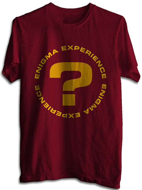 A maroon colored t-shirt with a circular text design that reads 'ENIGMA EXPERIENCE' and includes a golden question mark in the center.