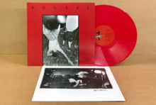 Cargar imagen en el visor de la galería, Red vinyl record with black and white album cover and additional photo on a brown background