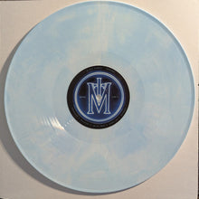 Charger l'image dans la galerie, Clear vinyl record with a blue label featuring a logo on a beige background