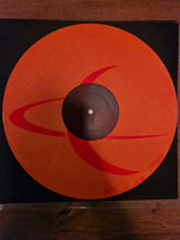 Cargar imagen en el visor de la galería, Vinyl record with a red and black cover on a wooden surface