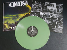Cargar imagen en el visor de la galería, Green vinyl record with 'Komatsu' album cover and black and white photos on a dark surface