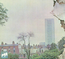 Load image into Gallery viewer, Tall building amidst residential houses with a blurred effect