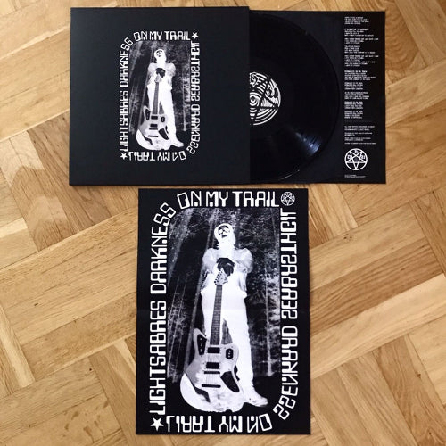 Vinyl record with cover and insert on a wooden floor