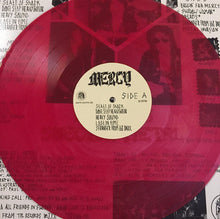 Cargar imagen en el visor de la galería, Red vinyl record with a beige label featuring the word 'Mercy' on a textured background.