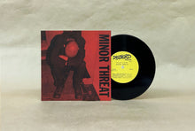 Charger l'image dans la galerie, Vinyl record with red cover featuring a person holding a red circle, on a beige background.
