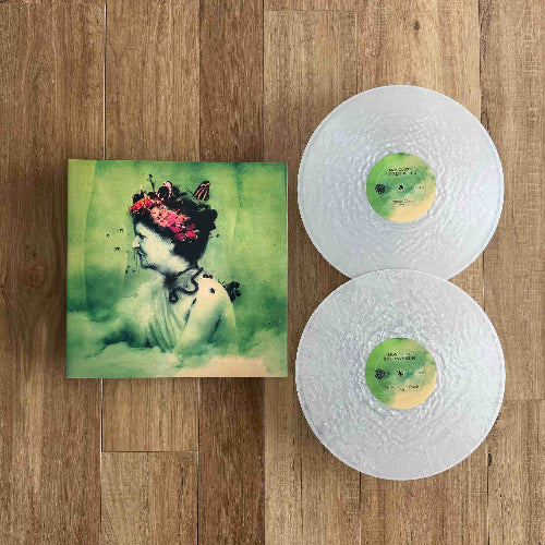Vinyl records with a cover featuring an artistic design on a wooden surface