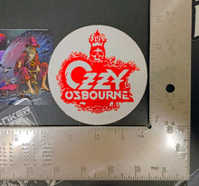 Charger l'image dans la galerie, Ozzy Osbourne logo sticker on a black surface with a ruler for scale.