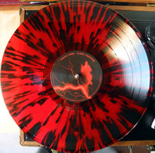 Load image into Gallery viewer, Vinyl record with red and black splatter design on a turntable