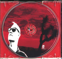 Charger l'image dans la galerie, CD cover with a silhouette of a person and a Joshua tree against a red background