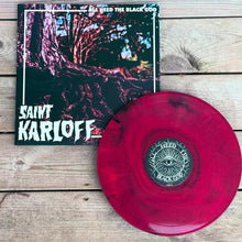 Load image into Gallery viewer, Vinyl record with red disc and black cover featuring 'Saint Karloff' and 'All Heed the Black God' on a wooden surface.