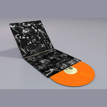 Load image into Gallery viewer, An open vinyl record sleeve with a black-and-white collage-style cover and an orange vinyl record partially pulled out, photographed on a smooth gray studio background.