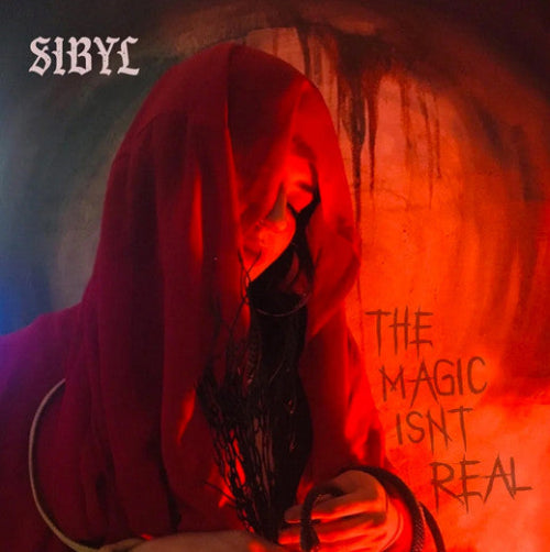 Album cover with a hooded figure holding a weapon, red and orange tones, and text 'The Magic Isn't Real'.