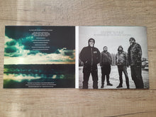 Load image into Gallery viewer, Music album with cover featuring a band and a scenic landscape on a wooden surface