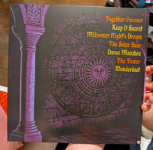 Cargar imagen en el visor de la galería, Book cover with purple design and yellow text held by a person