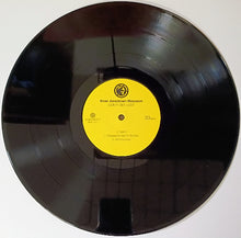 Charger l&#39;image dans la galerie, Vinyl record with a yellow label on a white background