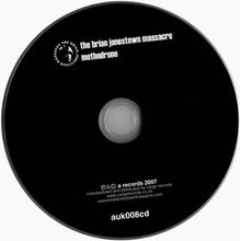Cargar imagen en el visor de la galería, A black compact disc with white printed text reading 'the brian jonestown massacre methodrone' and 'auk008cd', photographed on a light gray background.