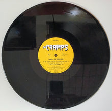 Cargar imagen en el visor de la galería, Vinyl record with a yellow label featuring &#39;The Cramps&#39; on a white background
