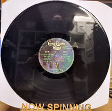 Cargar imagen en el visor de la galería, Vinyl record with a label on a white background, labeled 'NOW SPINNING'.