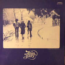Charger l'image dans la galerie, Album cover of Thin Lizzy featuring three band members walking in the rain with an umbrella.