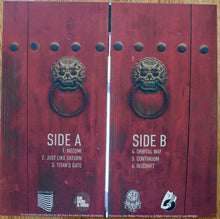 Charger l&#39;image dans la galerie, Vinyl record with red gate design and text on a wooden surface