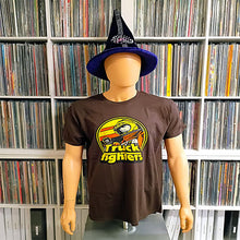 Cargar imagen en el visor de la galería, A mannequin wearing a dark brown graphic t-shirt with a 'The Truck Fighters' logo and a purple witch hat, set against a background of shelves filled with CD cases.