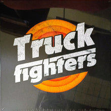 Cargar imagen en el visor de la galería, Sticker with 'Truckfighters' text and sunset design on a reflective surface
