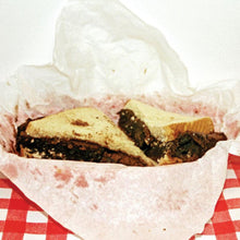 Cargar imagen en el visor de la galería, Two brownies in a clear plastic bag on a red and white checkered tablecloth.
