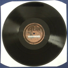 Charger l'image dans la galerie, A black vinyl record with a tan center label reading 'Impetus Videodrones' on a white backing card against a blue background.