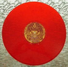 Charger l'image dans la galerie, Red vinyl record with a gold label on a textured surface