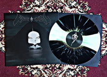 Load image into Gallery viewer, Vinyl record with a black and white design on a textured surface