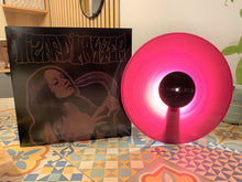 Cargar imagen en el visor de la galería, Vinyl record with pink disc and cover featuring a woman's face on a patterned floor.
