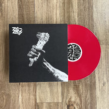 Load image into Gallery viewer, Vinyl record with black and white cover and red disc on a wooden surface