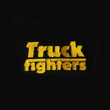Charger l'image dans la galerie, A close-up of a black textured surface, likely a hat or garment, featuring the words 'Truck fighters' embroidered in a bold, distressed yellow font.