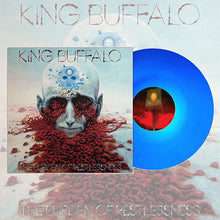 Load image into Gallery viewer, Album artwork for King Buffalo’s The Burden of Restlessness shown alongside a translucent blue vinyl record. The cover features a surreal illustration of a bald head with glowing symbols on the forehead, red organic tendrils flowing from the eyes and mouth across a pale desert-like landscape.